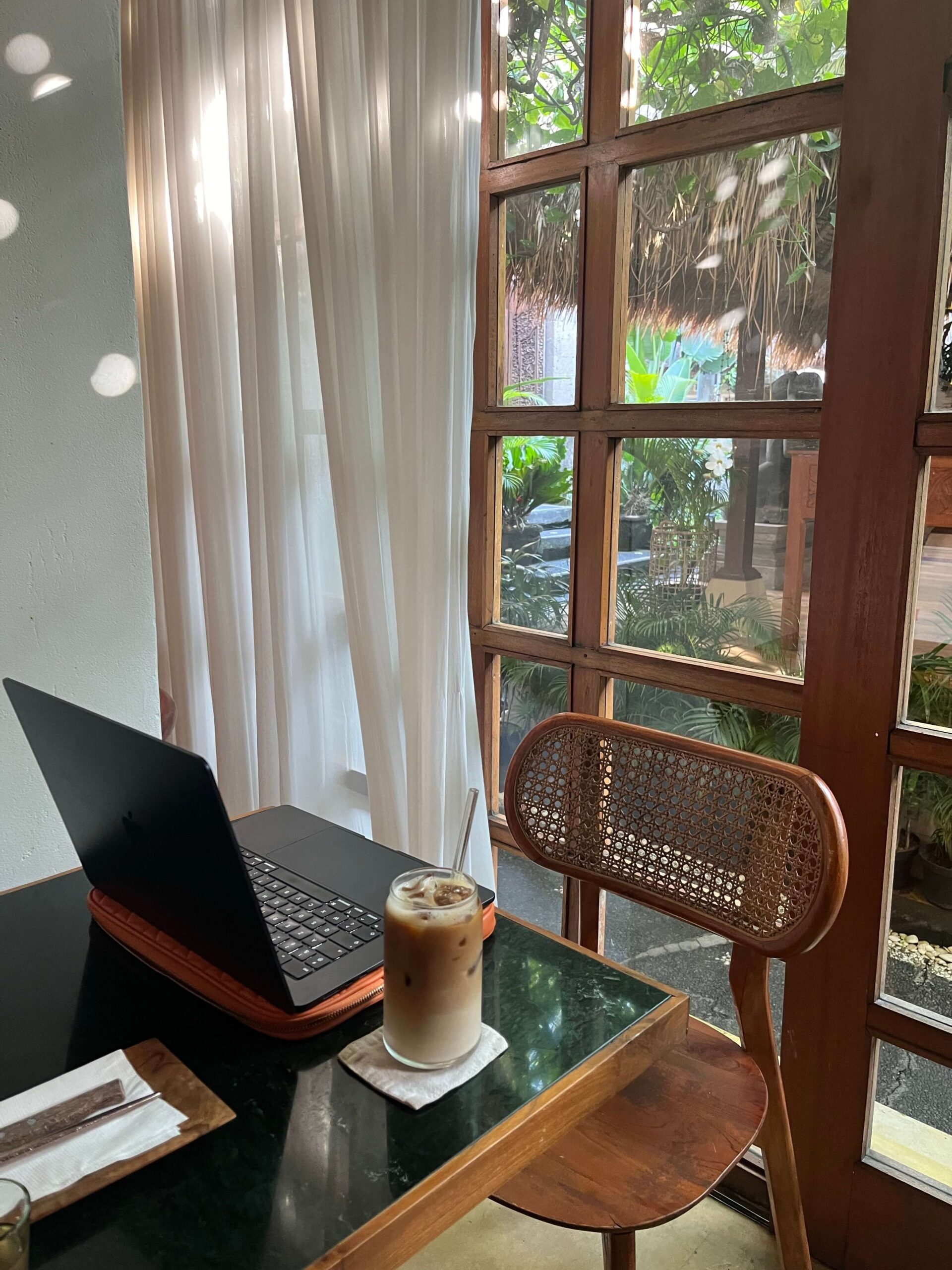laptop and iced coffee on a desk