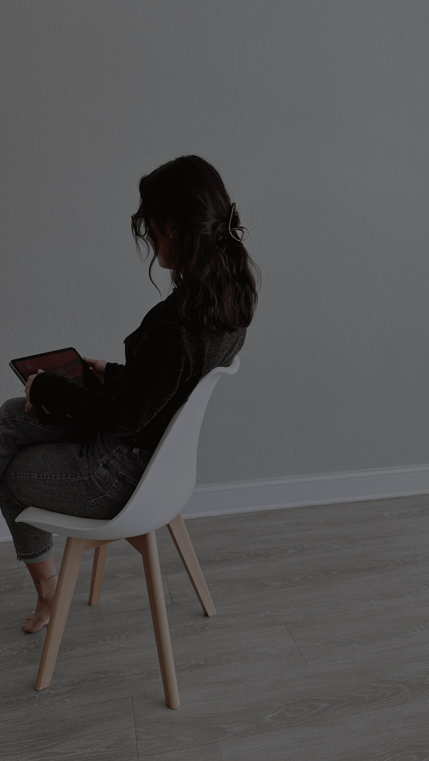 woman sitting in a chair holding an ipad